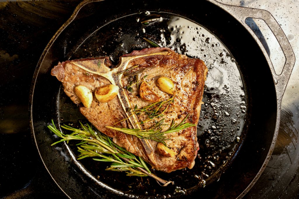 Juicy T-bone Beef Steak in a Cast Iron Skillet