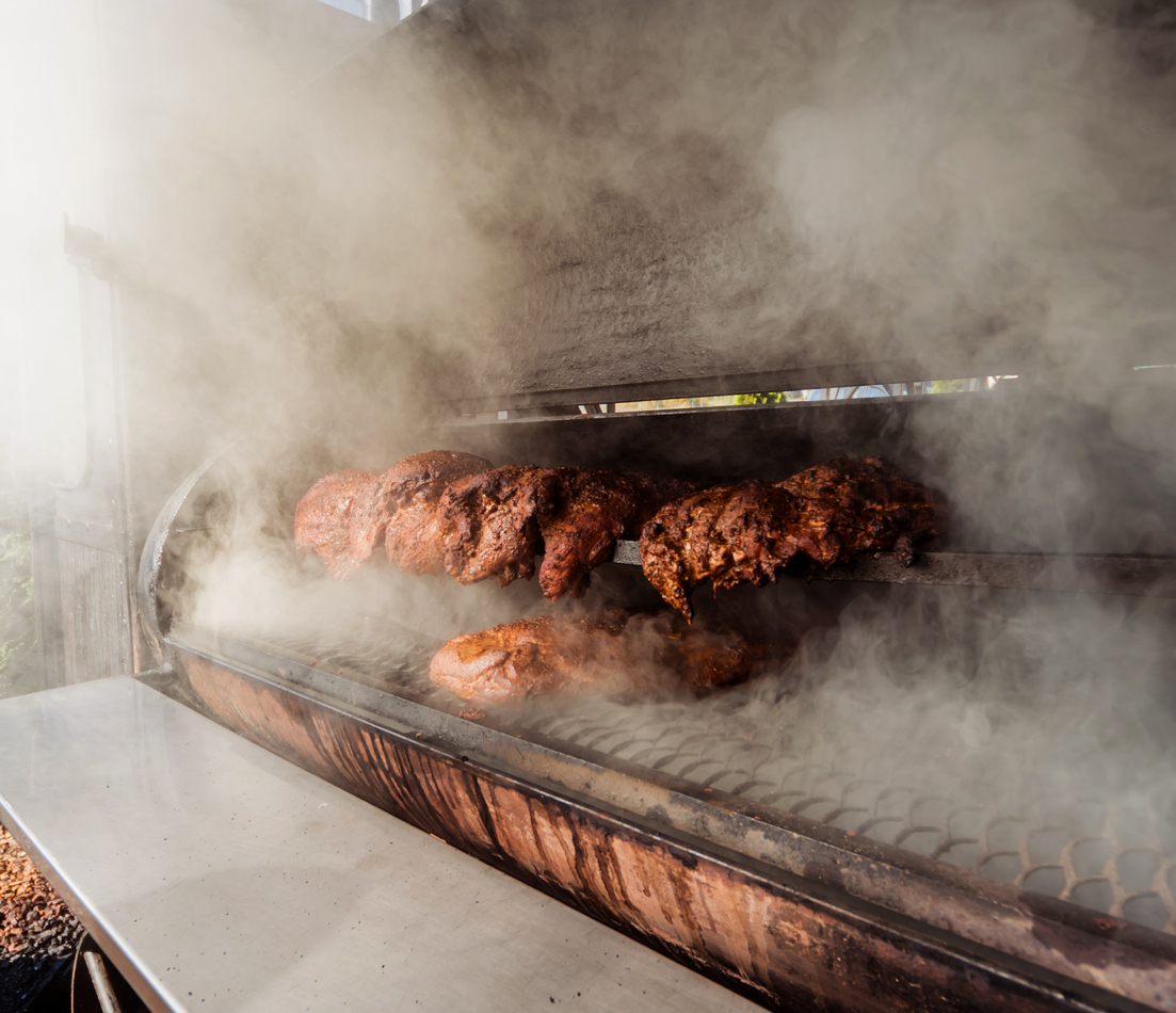 Large barbecue smoker grill at the park. Meat prepared in barbecue smoker.